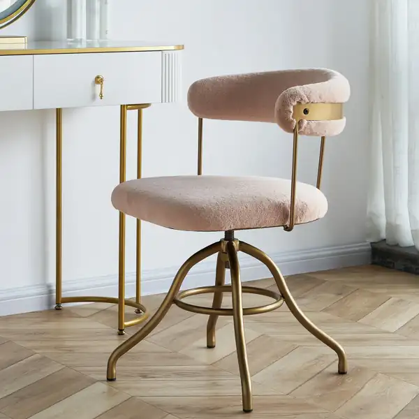 Blush pink faux fur vanity chair with a gold metal frame.