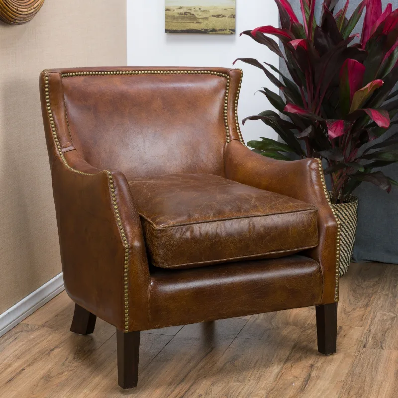 Distressed brown leather armchair with brass nailhead trim.