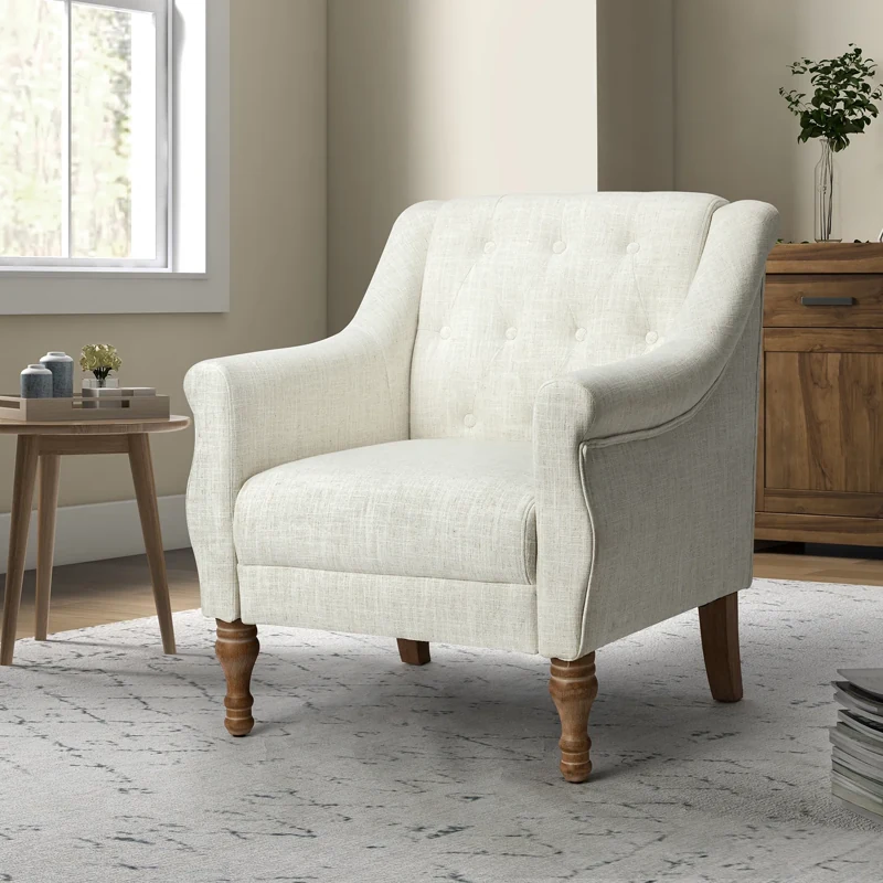 Off-white tufted armchair with wood legs.