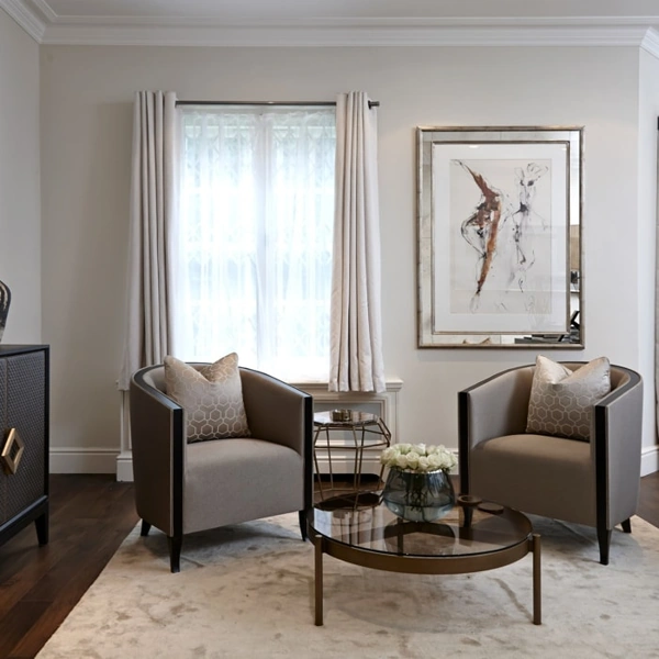 Pair of grey tub chairs in a bright living room.