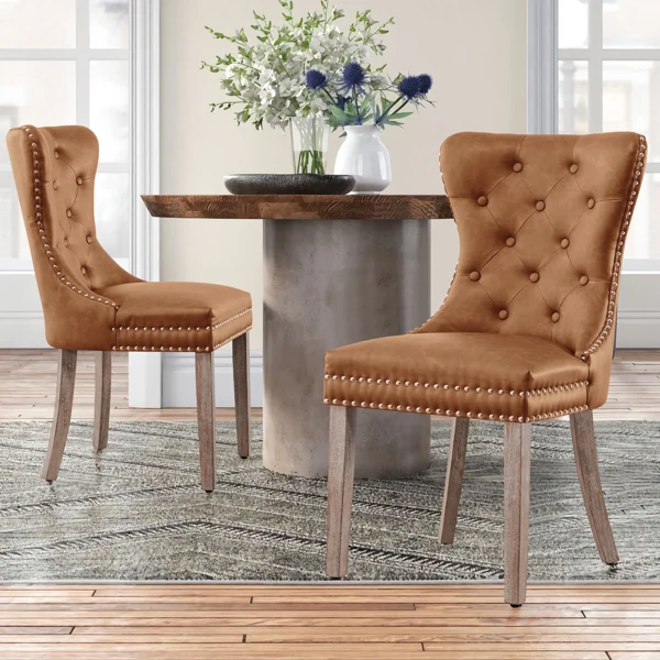 Pair of tufted tan leather dining chairs