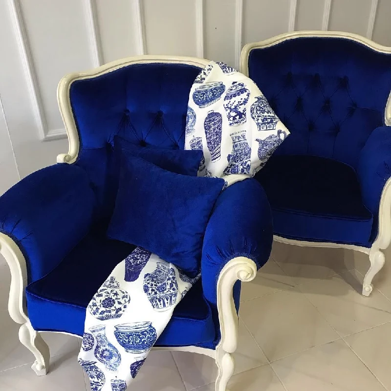 Royal blue velvet tufted chair with ginger jar patterned fabric.