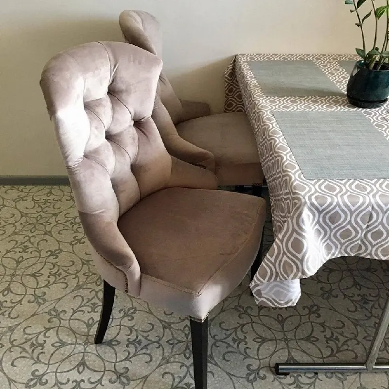 Tufted beige velvet dining chair with wingback design.